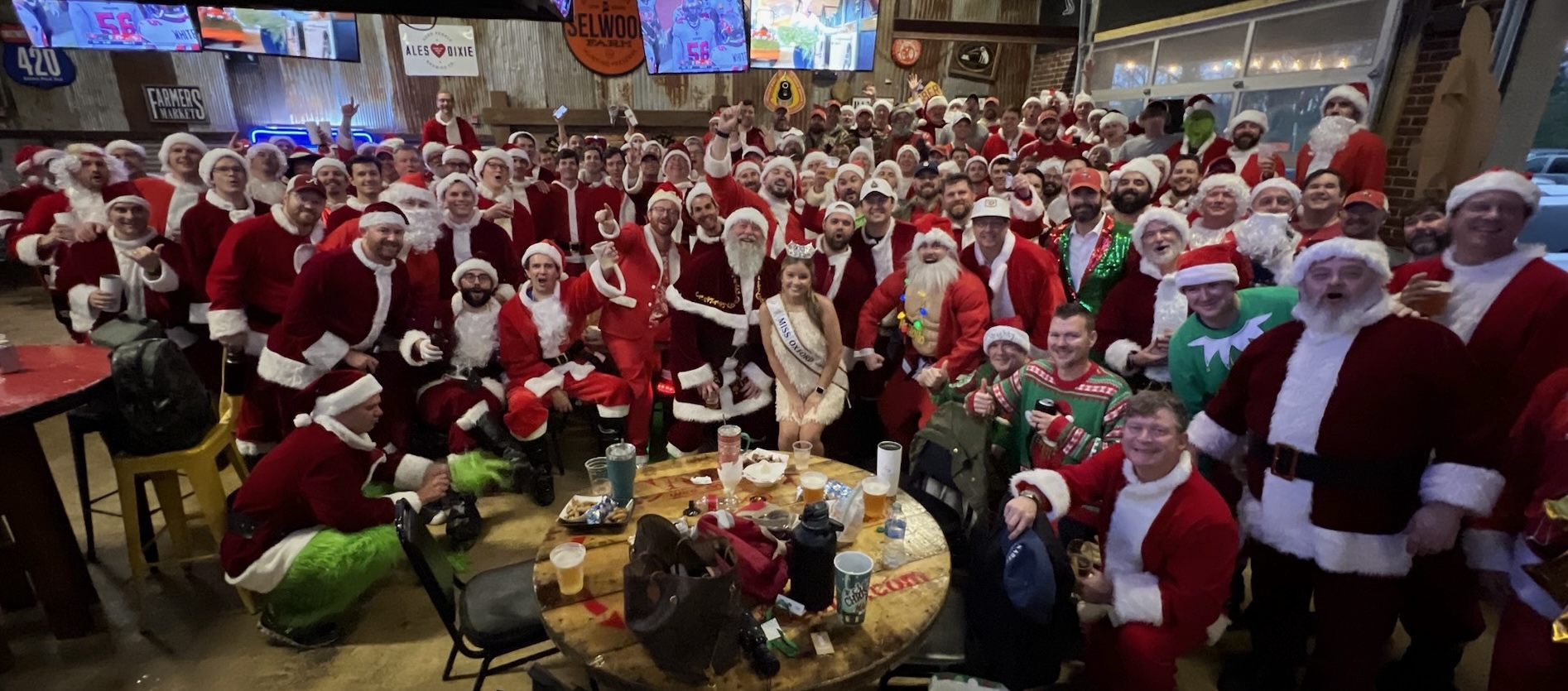 A huge crowd of men dressed as Santa Claus packed into The Grocery Brewpub, celebrating together after a past Walk for a Claus